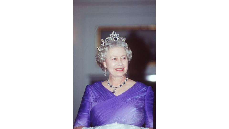 The late Queen wearing The King George Vi Victorian Suite Of Diamonds And Sapphires at a banquet on The Royal Yacht Britannia.