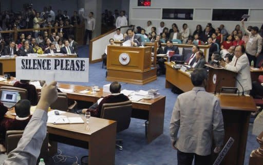 Senate security personnel call for silence as Philippine Supreme Court Chief Justice Renato Corona testifies during his impeachment trial in Manila. Corona denied he was a crook as he testified then dramatically walked out at his own trial