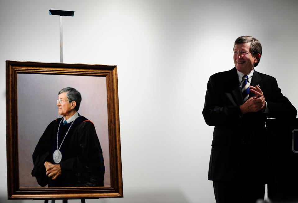 President Emeritus William A. Bloodworth Jr. stands near his likeness in a painting which was unveiled during a ceremony in Washington Hall at the Mary S. Byrd Gallery of Art on campus at Augusta University on Tuesday, December 18, 2012 in Augusta, Georgia.