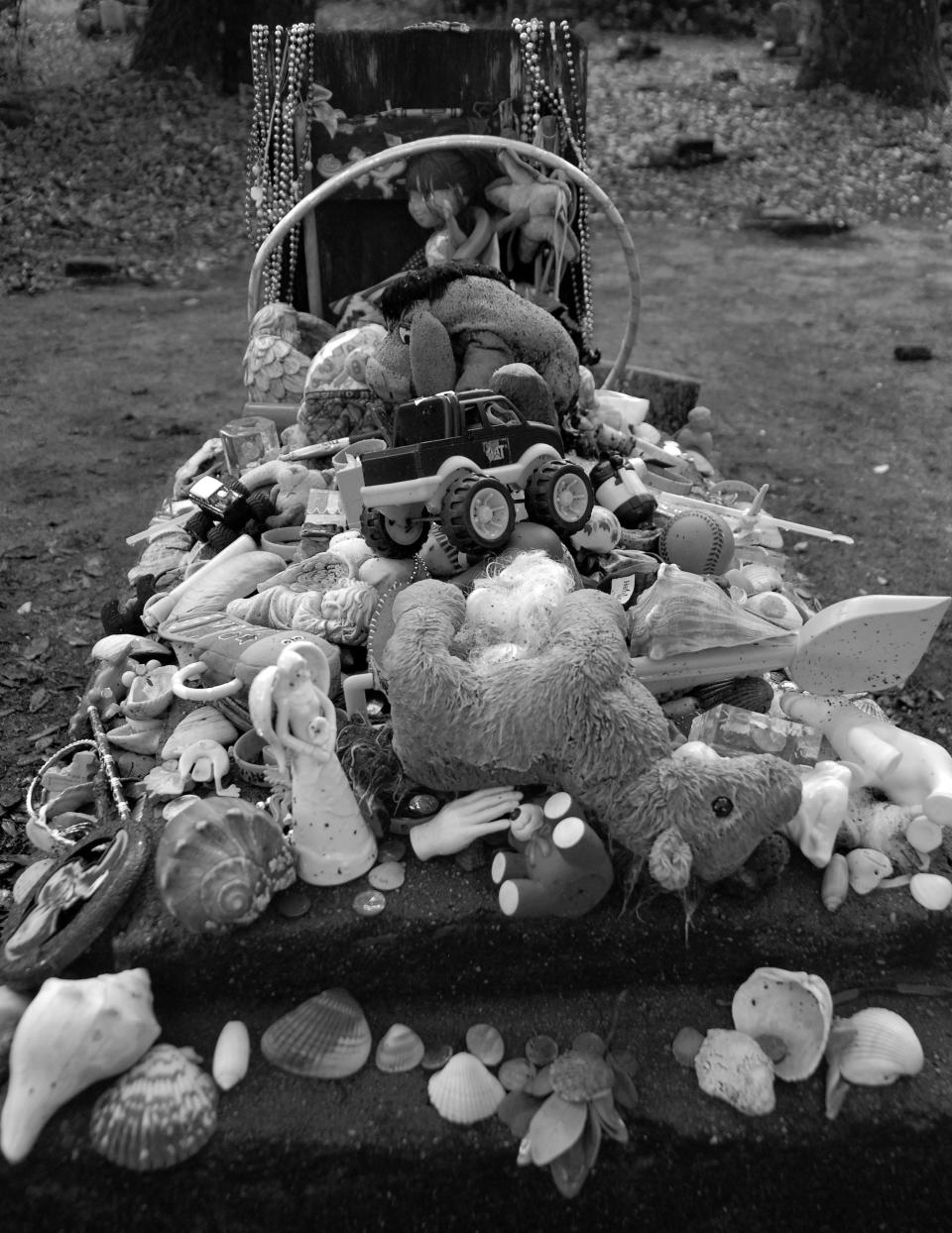 The grave of a young girl who died at sea while on a voyage with her father is decorated with gifts from visitors to the Old Burying Ground.