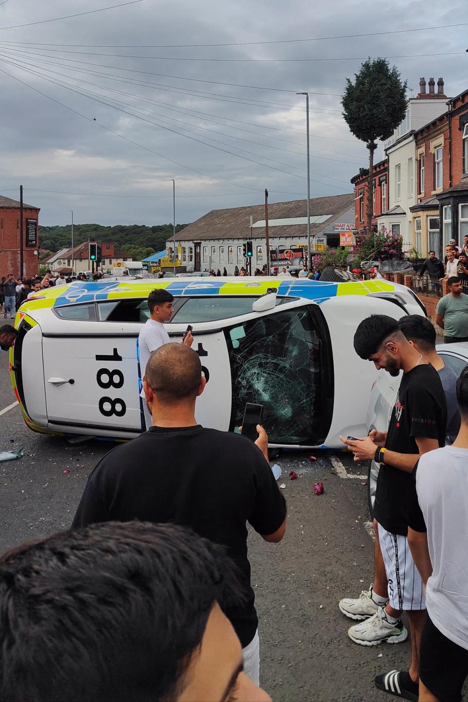 A police car was overturned as part of the disorder (@robin_singh/Instagram via Reuters)