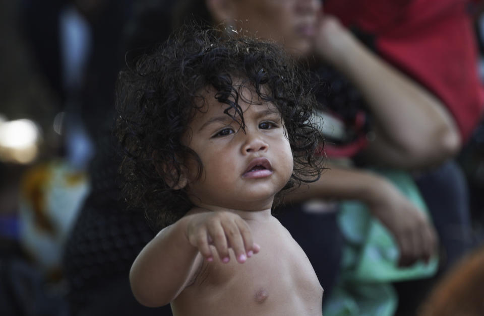 A toddler, who is part of a migrant caravan on a trek to the U.S. border, stands up during a rest period on the outskirts of Villa Comaltitlan, Chiapas state, Mexico, Wednesday, Oct. 27, 2021. (AP Photo/Marco Ugarte)