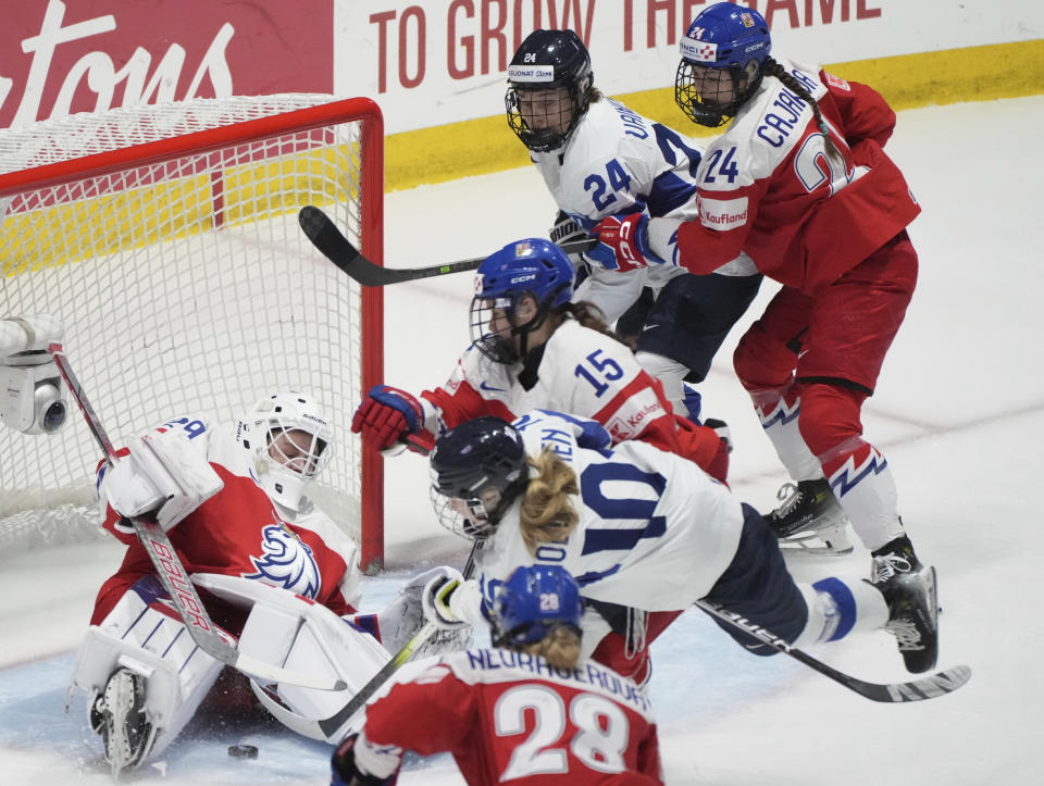 Czechia goaltender Klara Peslarova (29) makes a save against Finland's Elisa Holopainen (10) during first-period bronze medal game action at the women's world hockey championships in Utica, N.Y., Sunday, April 14, 2024. (Christinne Muschi/The Canadian Press via AP)