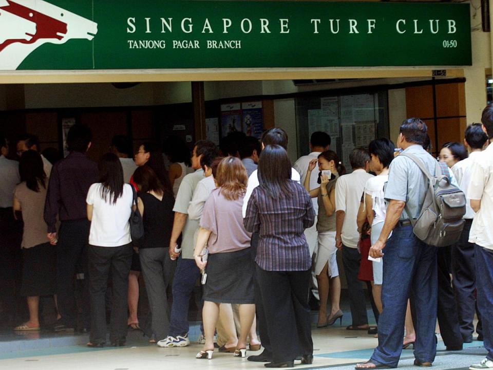 People queue up to place bet for the annual ToTo Hongbao draw at a Singapore Turf Club booth in 2004 (AFP via Getty Images)