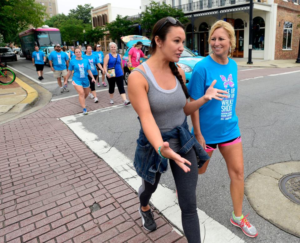 Sara Gillianne, left, and Jamie Cochran walk down Palafox Street to raise awareness for child abuse as part of a previous Walk in My Shoes with Lauren Book.