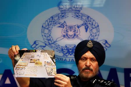 Commissioner Amar Singh, Malaysia's Federal Commercial Crime Investigation Department (CCID) director, displays a photo of items from a raid during a news conference in Kuala Lumpur, Malaysia June 27, 2018. REUTERS/Lai Seng Sin