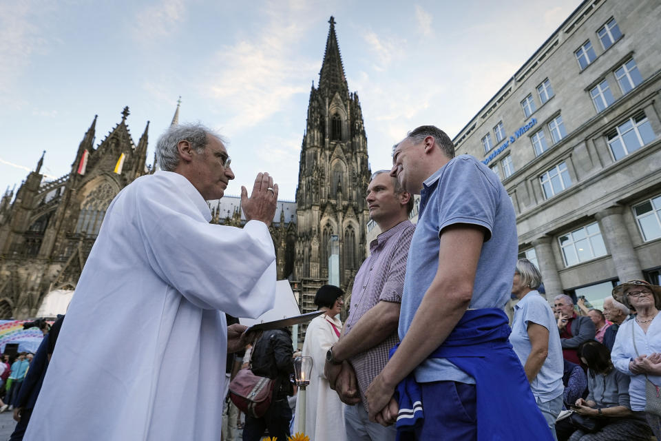 FILE - Same-sex couples take part in a public blessing ceremony in front of the Cologne Cathedral in Cologne, Germany, on Sept. 20, 2023. Pope Francis has formally approved allowing priests to bless same-sex couples, with a new document released Monday Dec. 18, 2023 explaining a radical change in Vatican policy by insisting that people seeking God’s love and mercy shouldn’t be subject to “an exhaustive moral analysis” to receive it. (AP Photo/Martin Meissner, File)