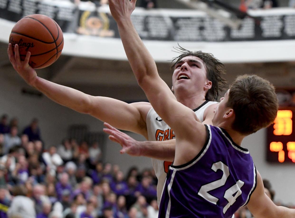 Green's Brady Rollyson puts up two points under pressure from Jackson's Kyle Monterrubio in the third quarter of Jackson at Green boys basketball. Friday, December 8, 2023.