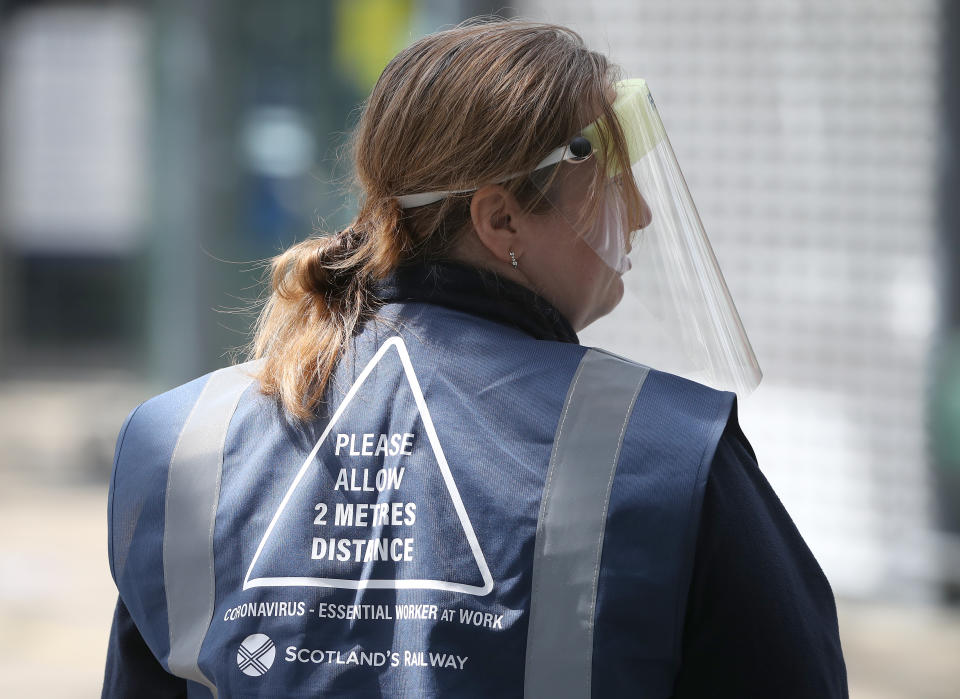 A person wears a jacket with Social distance guidelines printed on it at Edinburgh Waverley Station as Scotland moves into phase one of the Scottish Government's plan for gradually lifting lockdown. (Photo by Andrew Milligan/PA Images via Getty Images)