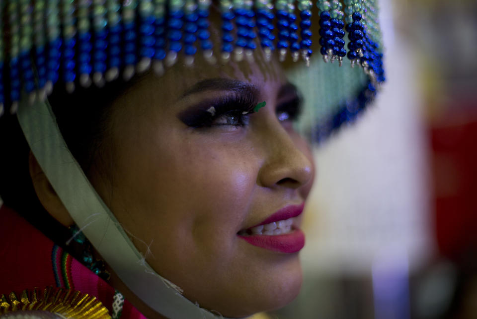 A contestant watches the Queen of Great Power contest, in La Paz, Bolivia, Friday, May 24, 2019. The largest religious festival in the Andes choses its queen in a tight contest to head the Festival of the Lord Jesus of the Great Power, mobilizing thousands of dancers and more than 4,000 musicians into the streets of La Paz. (AP Photo/Juan Karita)