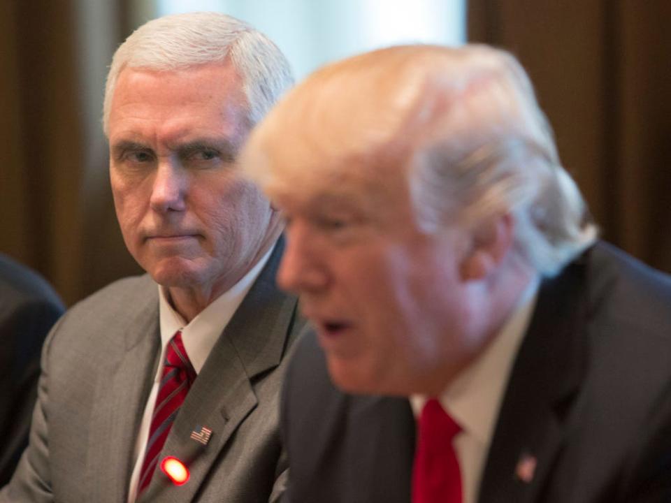 Mike Pence looking with an intense expression on his face while Donald Trump speaks.