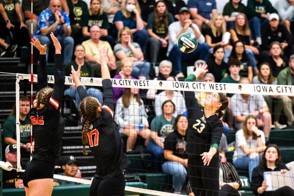 Iowa City West's Lily Prochaska (23) puts up an attack against Iowa City High's Emmy McComas, left, and Ruby McDonough on Tuesday.