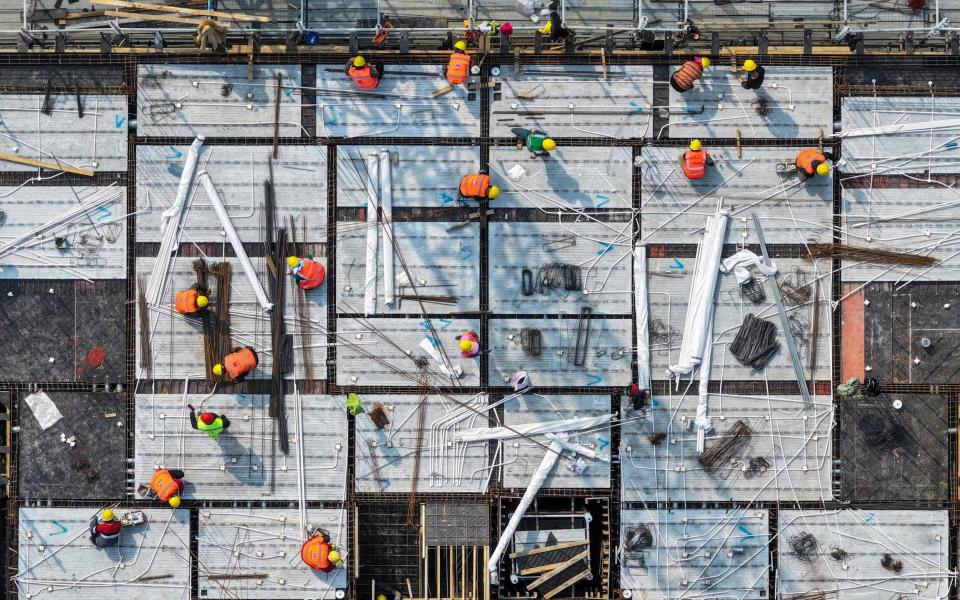 Workers on a rooftop of a residential building under construction in Nanjing, in eastern China's Jiangsu province, earlier this month