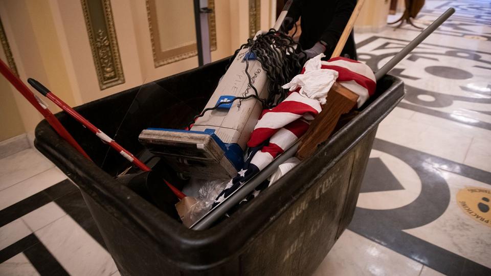 A worker pushes a trash bin at the U.S. Capitol building in Washington, D.C., U.S., on Thursday, Jan. 7, 2021. Joe Biden was formally recognized by Congress as the next U.S. president early Thursday, ending two months of failed challenges by his predecessor, Donald Trump, that exploded into violence at the U.S. Capitol as lawmakers met to ratify the election result.