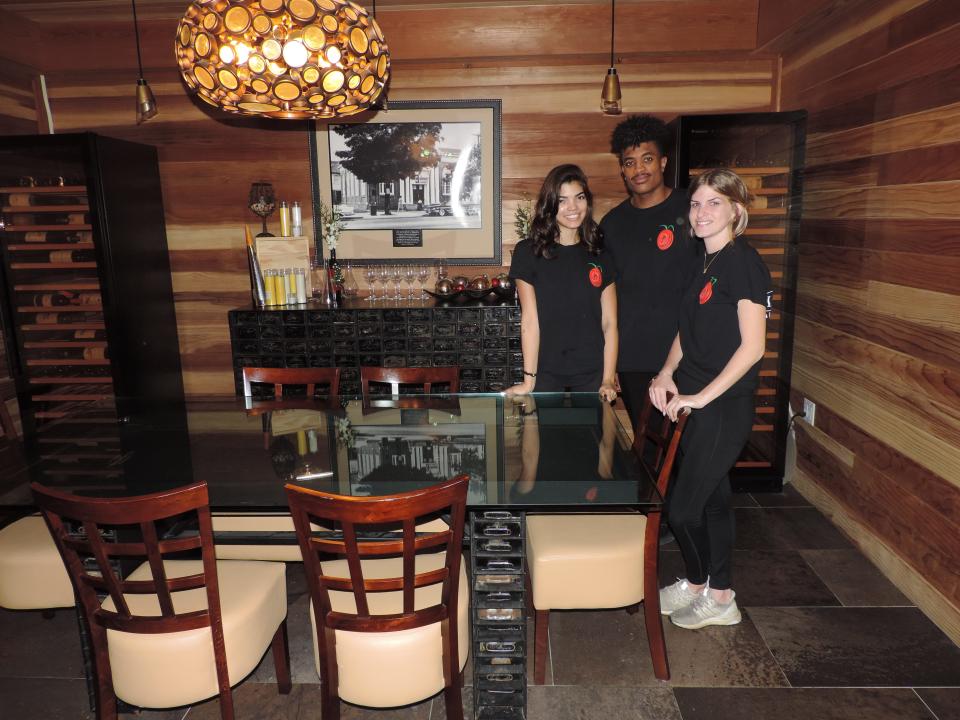 La Banca staff members, from left, Devon Wallace, Dawane Wallace and Maddie Wines, stand inside the former Delaware Trust bank vault, now used as a private dining room, at La Banca restaurant in Middletown. Former safe deposit boxes were used to make the dining table and the serving table in back of the vault.