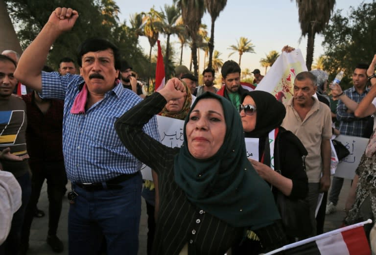 Iraqis shout slogans and raise national flags during a protest against poor services, unemployment and corruption as they gather in the capital Baghdad's Tahrir Square on July 13, 2018