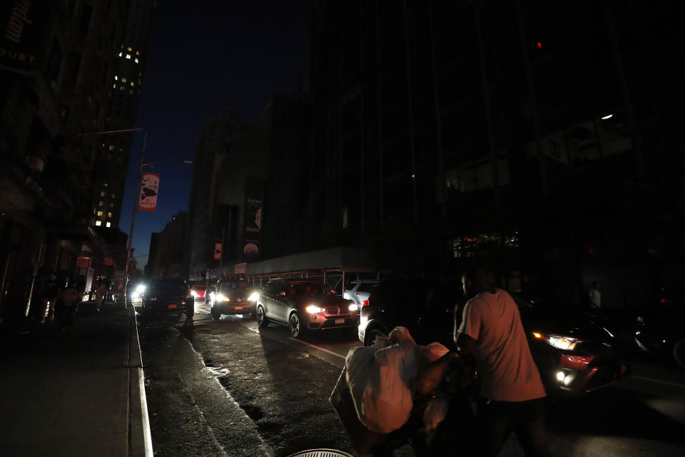 A man makes his way through a dark Times Square during a power outage, Saturday, July 13, 2019, in New York. Authorities were scrambling to restore electricity to Manhattan following a power outage that knocked out Times Square's towering electronic screens and darkened marquees in the theater district and left businesses without electricity, elevators stuck and subway cars stalled. (AP Photo/Michael Owens)