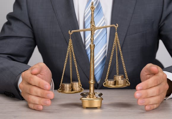 Businessman with a scale weighing coins