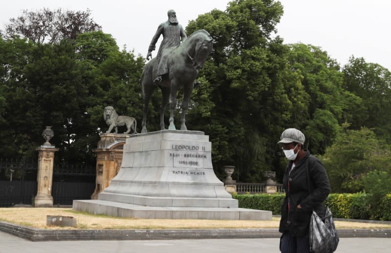 Person walks past the statue of Belgian King Leopold II, near Brussels' Royal Palace, in Brussels