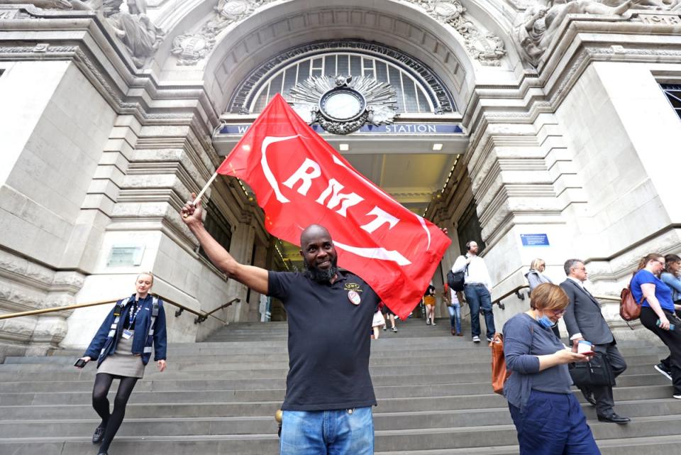 An RMT union member outside Waterloo station (James Manning/PA) (PA Wire)