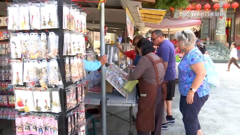 歐美旅客逛龍虎塔周邊紀念品區。