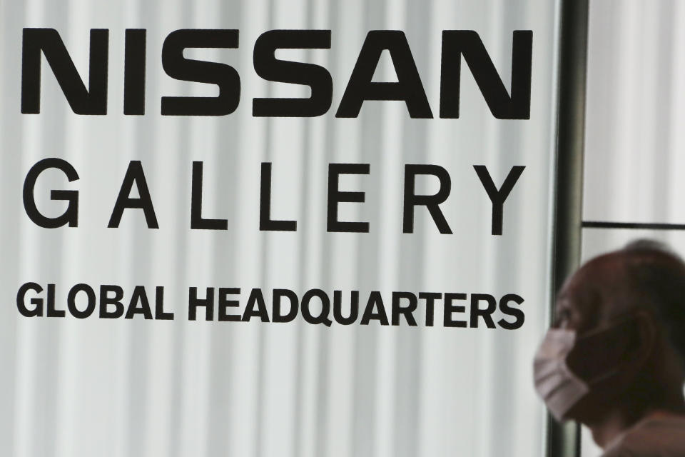 A man walks past the global headquarters of Nissan Motor Co., Ltd. in Yokohama near Tokyo, Wednesday, May 27, 2020. The Japanese-French auto alliance of Nissan and Renault will be sharing more vehicle parts, technology and models to save costs as the industry struggles to survive the coronavirus pandemic. (AP Photo/Koji Sasahara)