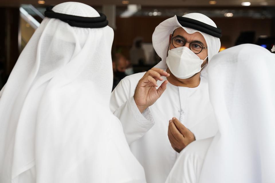 Emirati Minister of Cabinet Affairs Mohammad al-Gergawi, center right, speaks to colleagues before an event announcing new economic programs in the United Arab Emirates in Dubai, United Arab Emirates, Sunday, Sept. 5, 2021. The United Arab Emirates announced Sunday a major plan to stimulate its economy and liberalize stringent residency laws for expatriates, as the country seeks to overhaul its finances and attract foreign residents and capital. (AP Photo/Jon Gambrell)