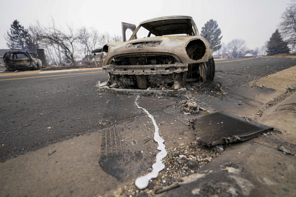 A burned out car sits on Mulberry Street destroyed by the Marshall Wildfire in Louisville, Colo., Friday, Dec. 31, 2021. (AP Photo/Jack Dempsey)