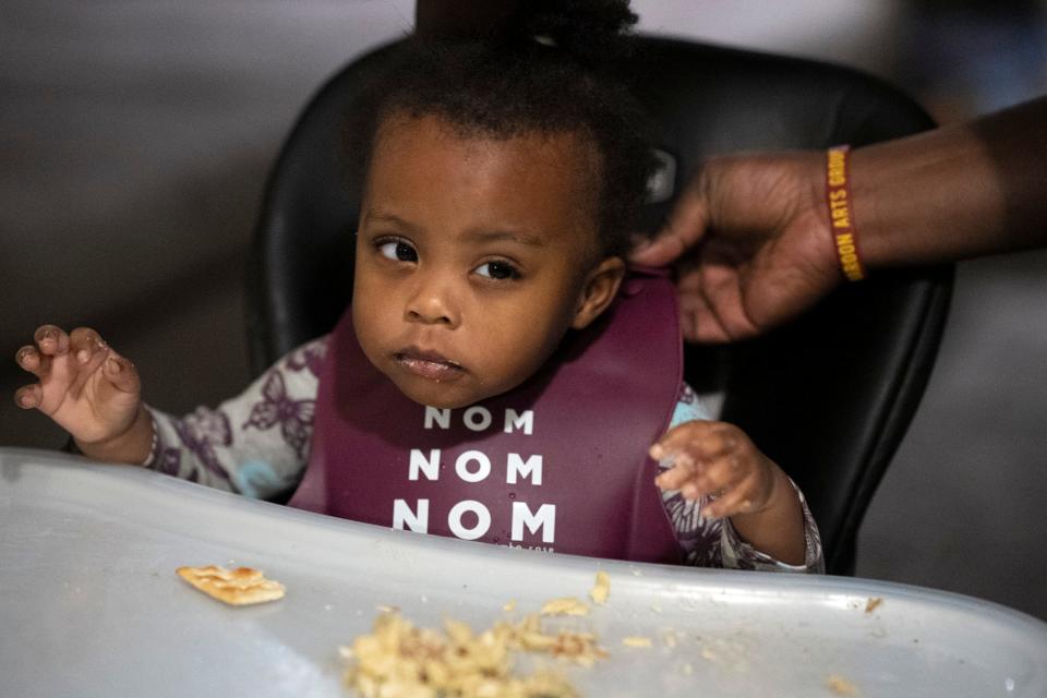 Zamya, 16 months, waits for her father, Ernest Levert Jr., to fasten her bib before continuing to eat dinner with him in their East Side home. “She’s mischievous,” Levert said with a smile. “She’ll run away and disappear for three minutes, and then all the clothes are on the floor.”