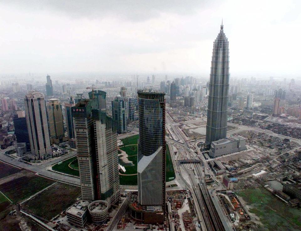 The 88-story Jin Mao Tower, right, as a new symbol of Shanghai, stand with other shorter buildings in Pudon New Developing Area Monday, March 22, 1999. Soaring 414 meters (1,358 feet), this skyscraper is the tallest building in China and the third in the world. The Grand Hyatt Shanghai Hotel fills the top third of the building, which is also the world's tallest hotel started its business on March 18. (AP Photo/Eugene Hoshiko)