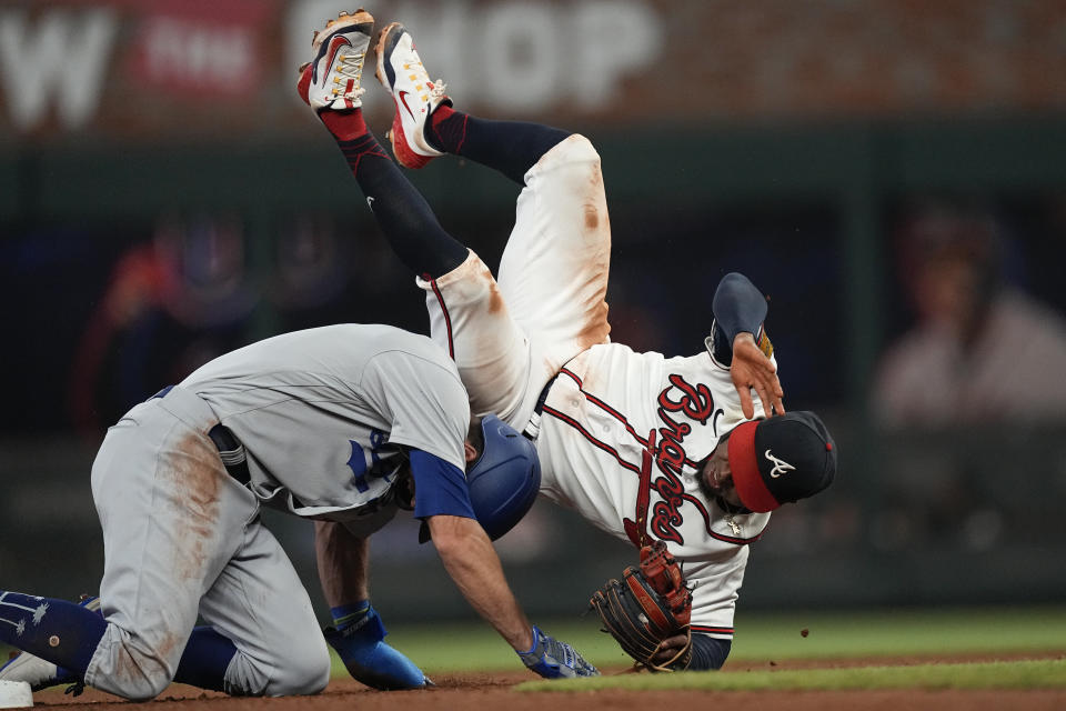 Atlanta Braves second baseman Ozzie Albies (1) tumbles over Los Angeles Dodgers' Chris Taylor (3) after forcing him out at second base on a Mookie Betts ground ball during the seventh inning of a baseball game Wednesday, May 24, 2023, in Atlanta. (AP Photo/John Bazemore)