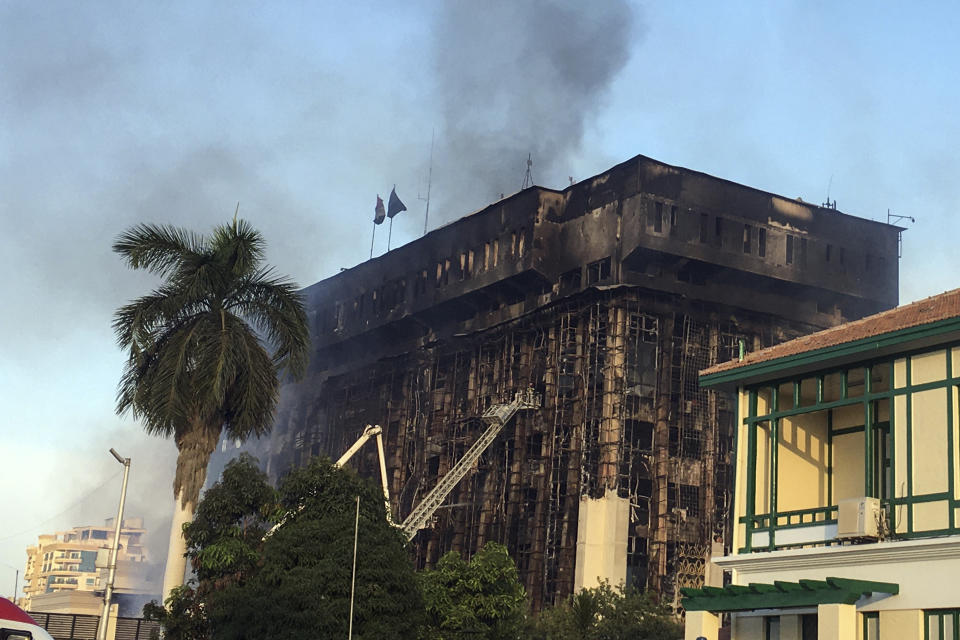 Firefighters climb up a ladder on the burning building of police headquarters in Ismailia, northeastern Egypt following a fire Monday, Oct. 2, 2023. A huge fire broke out early Monday in the police headquarters, injuring multiple people, the health ministry said. (AP Photo/Mohammed Awad)