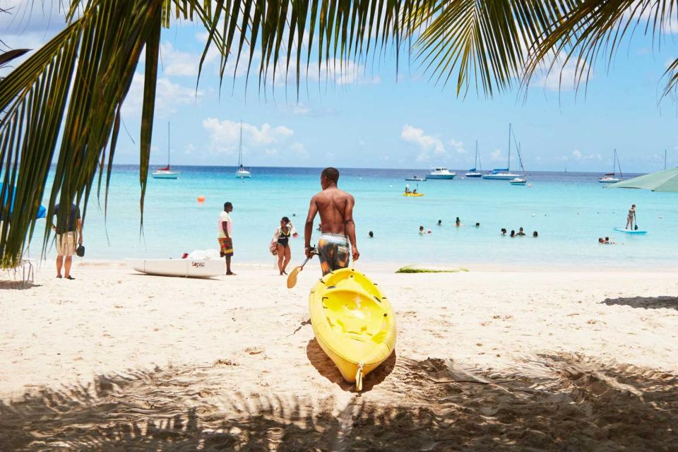 A man with a kayak on the beach in Barbados