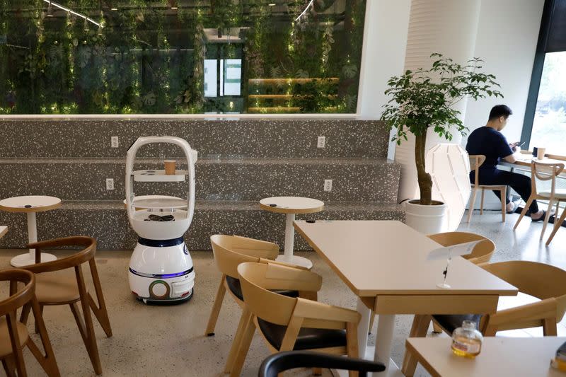 A robot that takes orders, makes coffee and brings the drinks straight to customers at their seats is seen at a cafe in Daejeon