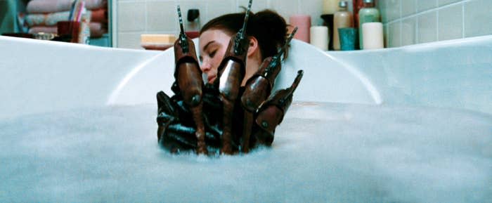 Rooney in a bathtub as Freddy Krueger's hand emerges from the water