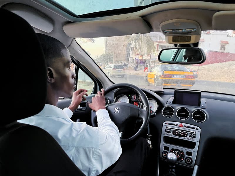 Abdourahmane, a user of the French ride-hailing app Heetch, is seen in his taxi in Dakar