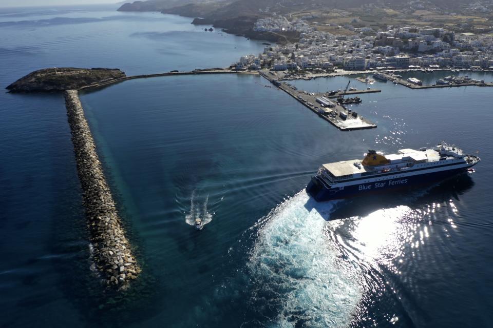 A ferry approaches the port on the Aegean island of Naxos, Greece, Friday, May 14, 2021. Greece launched its tourism season Friday amid a competitive scramble across the Mediterranean to lure vacationers emerging from lockdowns. (AP Photo/Thanassis Stavrakis)