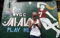 A gambler writes down his horse racing bet ouside a gambling joint in Malabon, Metro Manila, Philippines, March 21, 2015. Horseracing is one of the more popular forms of sports betting, both legal and illegal, in the Philippines. When paying your final respects for a relative or friend, the last thing you might expect to see at the wake is people placing bets on a card game or bingo. Not in the Philippines. Filipinos, like many Asians, love their gambling. But making wagers on games such as "sakla", the local version of Spanish tarot cards, is particularly common at wakes because the family of the deceased gets a share of the winnings to help cover funeral expenses. Authorities have sought to regulate betting but illegal games persist, with men and women, rich and poor, betting on anything from cockfighting to the Basque hard-rubber ball game of jai-alai, basketball to spider races. Many told Reuters photographer Erik De Castro that gambling is only an entertaining diversion in a country where two-fifths of the population live on $2 a day. But he found that some gamble every day. Casino security personnel told of customers begging to be banned from the premises, while a financier who lends gamblers money at high interest described the dozens of vehicles and wads of land titles given as collateral by those hoping lady luck would bring them riches. REUTERS/Erik De Castro PICTURE 26 OF 29 FOR WIDER IMAGE STORY "HIGH STAKES IN MANILA". SEARCH "BINGO ERIK" FOR ALL IMAGES.