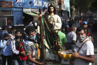 Faithful wearing protective face masks amid the new coronavirus, arrive to the San Hipolito Catholic church as part of the annual pilgrimage honoring Saint Jude, the patron saint of lost causes, in Mexico City, Wednesday, Oct. 28, 2020. Thousands of Mexicans did not miss this year to mark St. Jude's feast day, but the pandemic caused Masses to be canceled and the rivers of people of other years were replaced by orderly lines of masked worshipers waiting their turn for a blessing. (AP Photo/Marco Ugarte)