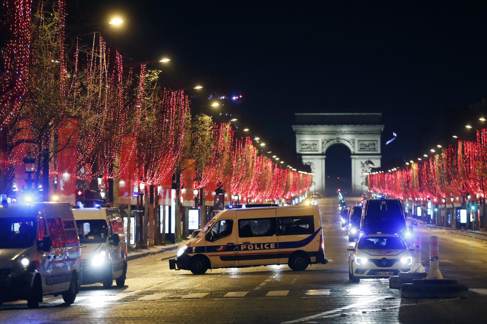 Police vans are parked on the Champs Elysees avenue during the New Year's Eve, in Paris, Thursday, Dec. 31, 2020. As the world says goodbye to 2020, there will be countdowns and live performances, but no massed jubilant crowds in traditional gathering spots like the Champs Elysees in Paris and New York City's Times Square this New Year's Eve. (AP Photo/Thibault Camus)