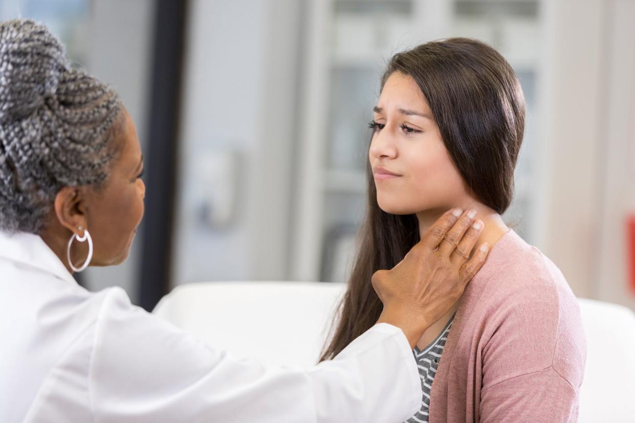 female doctor examines teenage patient