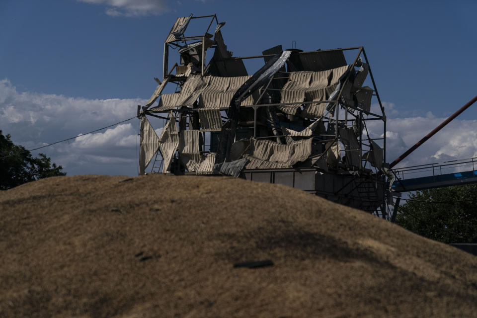 A mangled tower stands behind a mound of grain burned in Russian missile attacks at a grain facility in Pavlivka, Ukraine, Saturday, July 22, 2023. (AP Photo/Jae C. Hong)