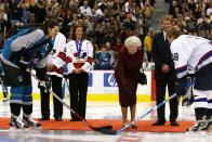 <p>KIM STALLKNECHT/AFP via Getty</p> Queen Elizabeth receives the ceremonial puck presented to her by former Edmonton Oilers and general manager of the men's Olympic hockey team Wayne Gretzky on October 6, 2002, in Vancouver, Canada.