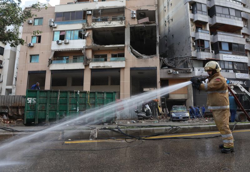 Un miembro de la defensa civil afiliado a Hezbolá rocía agua en un lugar dañado tras lo que, según fuentes de seguridad, fue un ataque israelí con drones en los suburbios de Dahiyeh, en el sur de Beirut