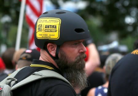 A man wears a sticker that says "Antifa Hunting Permit" at a Proud Boys rally in Portland, Oregon