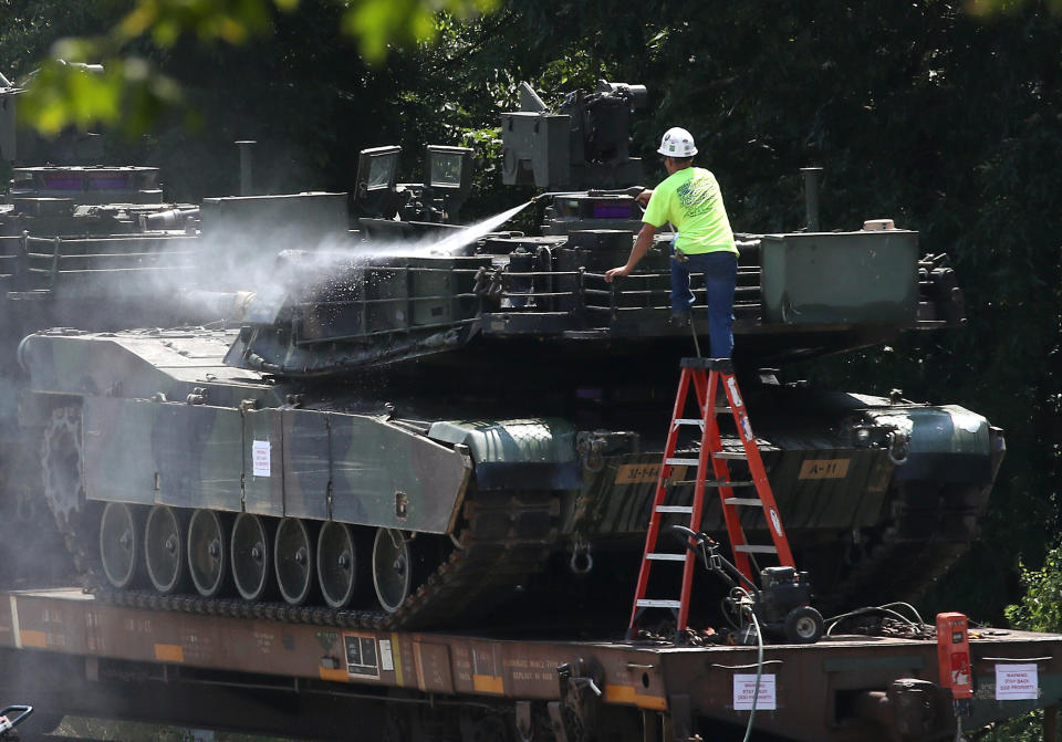 A worker washes one of two M1A1 Abrams tanks that are loaded on rail cars July 2 in Washington, D.C. (Photo: Mark Wilson/Getty Images)