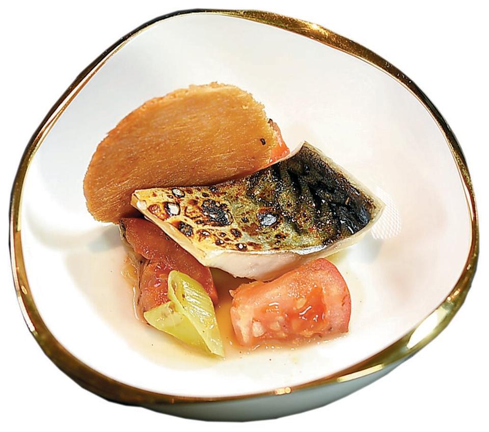 〈魚片米粉〉是以炭烤鯖魚搭配火烤玉女番茄、麵線，再加入用雞、豬、魚骨熬製的底湯，與煉奶、大量蔬菜煮成的濃湯一起享用。圖／姚舜