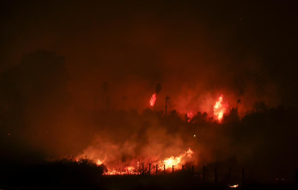 A wildfire burns in Riverside, Calif. Thursday, Oct. 31, 2019. Santa Ana winds are expected to linger for a final day after driving more than a dozen wildfires through California. (AP Photo/Ringo H.W. Chiu)