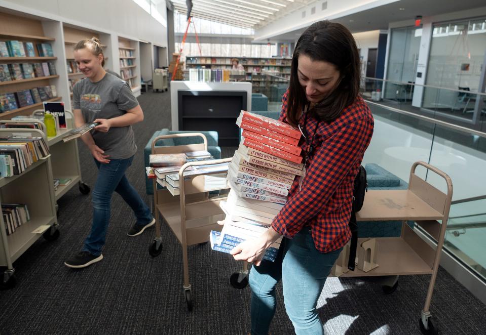 Chrissie Harris, a selection librarian, carries a stack of books by Colleen Hoover to be reshelved as a special display at the new Gahanna Columbus Metropolitan Library location on Wednesday. It will officially open Saturday and serve the city of almost 36,000, as well as Jefferson and Mifflin townships.