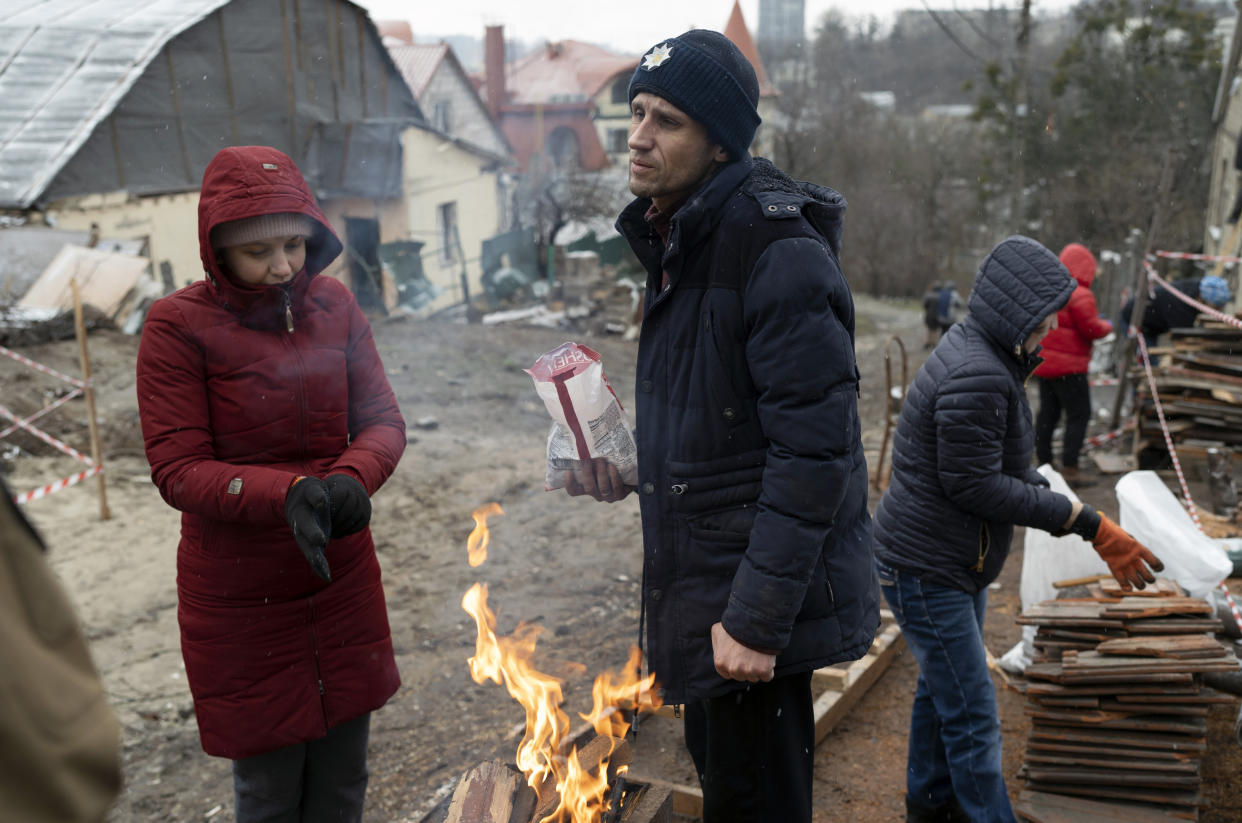 Serhii Kaharlytskiy, center, talks to volunteers helping him to reconstruct his house, destroyed during a Russian attack on Dec. 31, 2022, before the start of the Orthodox Christmas, in Kyiv, Ukraine, Friday, Jan. 6, 2023. Russian President Vladimir Putin on Thursday ordered Moscow's armed forces to observe a 36-hour cease-fire in Ukraine this weekend for the Russian Orthodox Christmas holiday, but Ukrainian President Volodymyr Zelenskyy questioned the Kremlin's intentions. (AP Photo/Roman Hrytsyna)